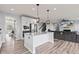 Open kitchen with stainless appliances flowing into the living room with fireplace and mounted television at 9917 Gallop Ln, Fishers, IN 46040