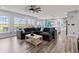 Bright living room featuring a gray sectional, hardwood floors, and views of the back yard at 9917 Gallop Ln, Fishers, IN 46040