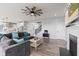 Comfortable living room showcasing hardwood floors, a cozy fireplace, and a modern ceiling fan at 9917 Gallop Ln, Fishers, IN 46040