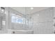 Spa-like shower with gray tile, glass surround, and rainfall shower head offers a luxurious bathing experience at 9917 Gallop Ln, Fishers, IN 46040