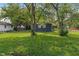 View of the backyard featuring a lush green lawn and a charming blue house exterior at 1002 Collier St, Indianapolis, IN 46241
