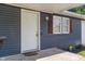 Close-up of the home's entrance with a white door, wooden shutters, and modern security at 1002 Collier St, Indianapolis, IN 46241