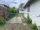 View of the backyard with a gated fence, greenery, and a partial view of the house at 1021 W 37Th St, Indianapolis, IN 46208