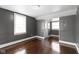 Bedroom featuring gray walls, wood floors, a closet, and two windows at 1021 W 37Th St, Indianapolis, IN 46208