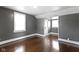Bedroom featuring gray walls, wood floors, a closet, and two windows at 1021 W 37Th St, Indianapolis, IN 46208