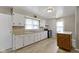 Well-lit kitchen featuring white cabinets, black appliances, an island, and laminate flooring at 1021 W 37Th St, Indianapolis, IN 46208