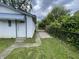 View of the shed featuring a white door, blue trim, and green shrubbery surrounding it at 1021 W 37Th St, Indianapolis, IN 46208