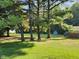 Backyard with lush green grass and several mature trees providing ample shade and privacy from neighboring homes at 10307 Orchard Park S Dr, Carmel, IN 46280