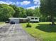 View of the front yard with a mix of brick and vinyl siding along with a long driveway leading up to the garage at 10307 Orchard Park S Dr, Carmel, IN 46280