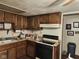 Classic kitchen with brown cabinets and a black stove, ready for your updates and personal touch at 10307 Orchard Park S Dr, Carmel, IN 46280