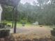 Enclosed patio area leads to a backyard with lush trees, an open shed, and space for gardening at 10307 Orchard Park S Dr, Carmel, IN 46280
