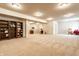 Finished basement features neutral carpet, shelving, and comfortable seating, ready for relaxation and entertaining at 1065 Park Ct, Avon, IN 46123