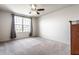 A bedroom with carpet, a ceiling fan, a window for natural light, and neutral-colored walls with a dark wooden dresser at 1065 Park Ct, Avon, IN 46123