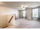An upstairs bonus room featuring plush carpeting, a ceiling fan, natural light, and a quaint rocking chair near the stairwell at 1065 Park Ct, Avon, IN 46123