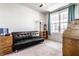A bonus room with a comfortable black futon couch and a ceiling fan for air circulation and a quaint writing desk at 1065 Park Ct, Avon, IN 46123
