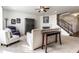 Inviting living room with neutral tones, a fireplace, a ceiling fan, and a staircase, perfect for comfortable living at 1065 Park Ct, Avon, IN 46123