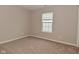 Cozy bedroom features neutral paint, plush carpeting, and a window for natural light at 10722 Mistflower Way, Indianapolis, IN 46235
