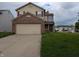 Two-story home featuring a brick-accented front, attached two-car garage, and neutral siding at 10722 Mistflower Way, Indianapolis, IN 46235