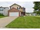 Inviting two-story home with a brick-accented garage and well-manicured lawn at 10722 Mistflower Way, Indianapolis, IN 46235