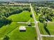 Wide aerial view of property featuring a house and outbuilding amid lush green surroundings at 10758 W State Road 142, Quincy, IN 47456
