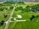 Aerial view showing the house, outbuilding, pond, and expansive green lot on a sunny day at 10758 W State Road 142, Quincy, IN 47456