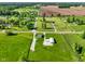 Aerial view showcases a house and outbuilding amid lush green surroundings at 10758 W State Road 142, Quincy, IN 47456