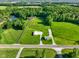 Wide aerial view of property featuring a house and outbuilding amid lush green surroundings at 10758 W State Road 142, Quincy, IN 47456