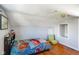 Cozy bedroom features hardwood floors, sloped ceilings, and a whimsical car-themed bedspread at 10758 W State Road 142, Quincy, IN 47456