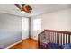 Bright bedroom featuring hardwood floors, a crib, and a window at 10758 W State Road 142, Quincy, IN 47456
