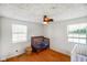 Well-lit Bedroom featuring hardwood floors, a ceiling fan, a crib, and natural light from the windows at 10758 W State Road 142, Quincy, IN 47456