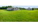 Property showcasing a vast lawn and a detached garage in the distance at 10758 W State Road 142, Quincy, IN 47456