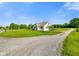 Charming home with a gravel driveway surrounded by a lush green lawn at 10758 W State Road 142, Quincy, IN 47456