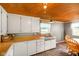 Well-lit kitchen featuring wood countertops, wood ceiling, modern sink, and wood-trim dining set at 10758 W State Road 142, Quincy, IN 47456