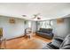 Bright living room with hardwood floors, comfortable seating, ceiling fan, and decorative wall art at 10758 W State Road 142, Quincy, IN 47456