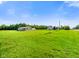 Expansive green lawn with clear blue skies and a house in the distance at 10758 W State Road 142, Quincy, IN 47456