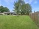 Large grassy backyard featuring a fence, mature trees, and lawn that enhances outdoor living at 108 N A St, Elwood, IN 46036