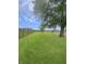 A serene backyard featuring a well-maintained lawn, mature trees, and a sturdy fence at 108 N A St, Elwood, IN 46036