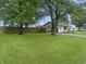 A spacious, green front lawn with a house and fence in the background at 108 N A St, Elwood, IN 46036
