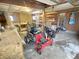 An open garage containing a small tractor, work benches, wood and materials, and tools at 108 N A St, Elwood, IN 46036