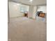 Open-concept living area with neutral carpeting and view into the kitchen at 108 N A St, Elwood, IN 46036