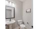 Cozy powder room featuring a pedestal sink, framed mirror, and stylish fixtures at 1085 Bevy Blvd, Danville, IN 46122