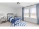 Comfortable bedroom with a metal frame bed, bright blue decor, and a large window view at 1088 Bevy Blvd, Danville, IN 46122
