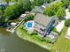 Stunning aerial view of the property showcasing a private pool, boat docks and waterfront access on a sunny day at 11061 Mast Ct, Fishers, IN 46040