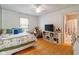 Cozy bedroom with hardwood floors, a ceiling fan, and a view of the attached bathroom at 11061 Mast Ct, Fishers, IN 46040