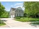 Exterior view highlighting the home's architecture, attached garage, well-maintained lawn, and expansive driveway at 11061 Mast Ct, Fishers, IN 46040