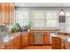 This kitchen offers stainless appliances, granite counters, wood cabinets, and a garden view at 11061 Mast Ct, Fishers, IN 46040