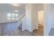 Open-concept living area with modern flooring, a staircase, and a view to the powder room at 1108 Bevy Blvd, Danville, IN 46122