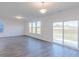 Spacious living room with wood-look floors, sliding glass doors, and large windows providing ample light at 1108 Bevy Blvd, Danville, IN 46122