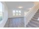 Living area featuring luxury vinyl plank flooring, a staircase and large windows offering lots of natural light at 1108 Bevy Blvd, Danville, IN 46122