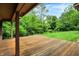 A wooden back porch overlooks a large, lush yard with mature trees providing privacy and shade at 11469 Woodview Ct, Fishers, IN 46038